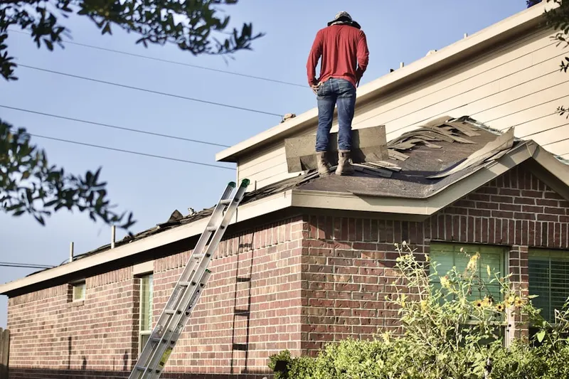 Professional roofer working on a residential roof in Brookline Village